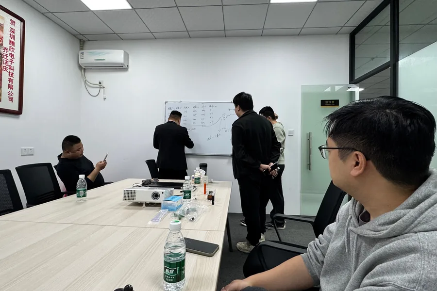 Engineers at a whiteboard working through voltage, current, temperature and power figures