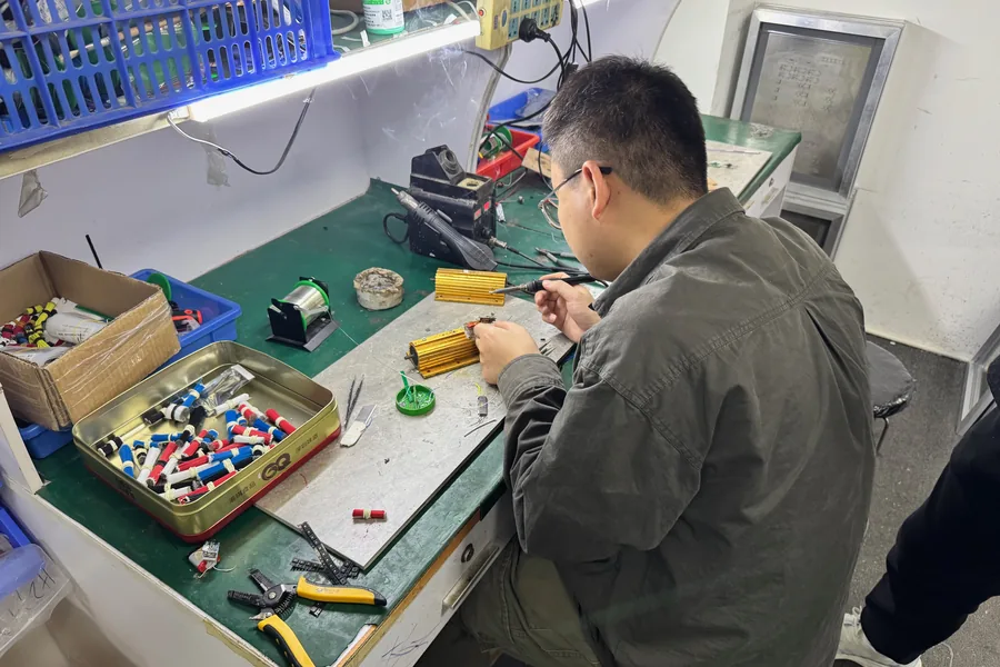 An engineer soldering components at a workbench during prototype builds