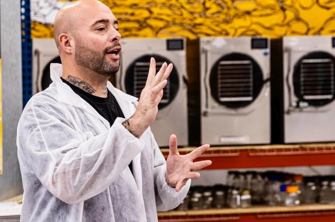 John Dawson Jr. in a lab coat presenting to a production team in front of processing equipment