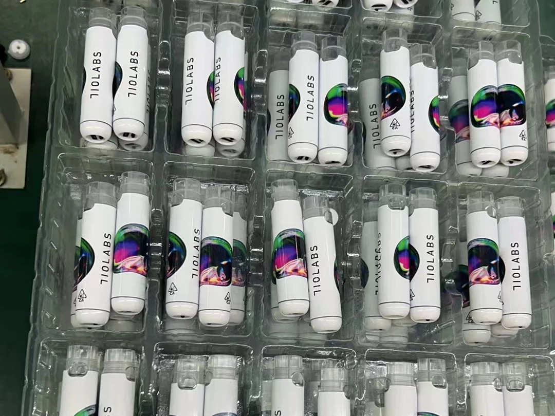 Trays of branded 710 Labs devices in white with full-wrap artwork, photographed on the factory floor